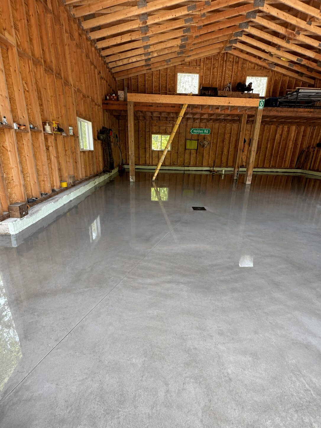 Large polished concrete garage floor inside a timber-framed structure
